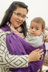 Young mother with her baby boy in a baby carrier scarf © guruXOX