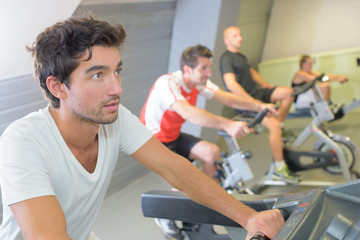 Fototapeta na wymiar Men on exercise bikes