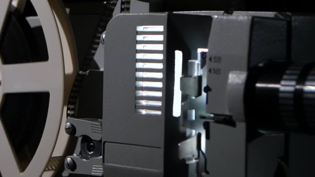 Movie projector that turns the film reel. Side view