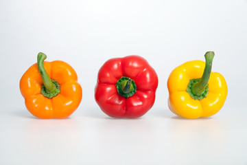 Orange, Red and Yellow Peppers on white background.