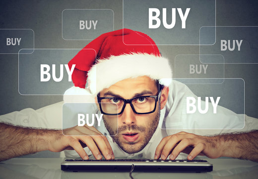 Christmas man in santa claus hat buying stuff online