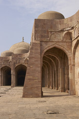 Fototapeta na wymiar Inner courtyard and covered prayer hall of the ancient mosque of Ashrafi Mahal Mosque in the hilltop fortress of Mandu in Madya Pradesh, India. 15th Century AD