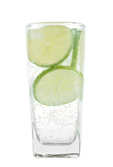 Full glass of fresh cool tonic with lime fruits isolated on whit