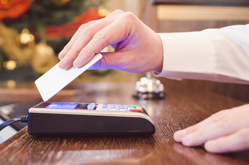 Man in white shirt paying bill with blank white contactless wave