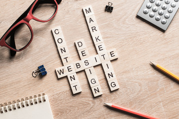 Conceptual business keywords on table with elements of game making crossword