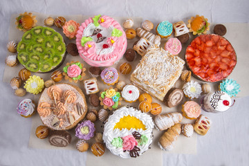 colorful muffins, flowers made of cream on to, isolated on white 
