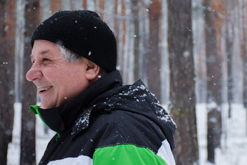 Happy old man in the winter forest