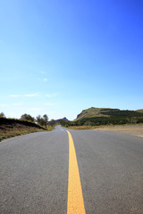 asphalt road on grassland
