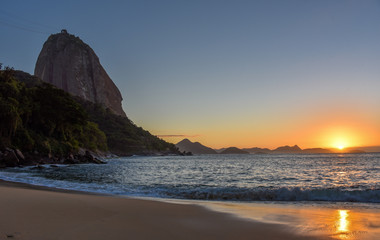 Beautiful sunrise at Praia Vermelha Beach, the sun rising from the Atlantic Ocean and the Sugarloaf Mountain, Rio de Janeiro, Brazil