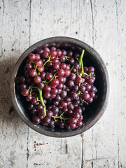 Red wine Grapes in a bowl on wood background