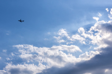 Small plane in blue sky with clouds background