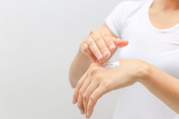 closeup female applying cream on her hand