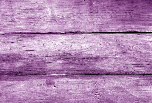 Magenta toned weathered wooden wall texture.