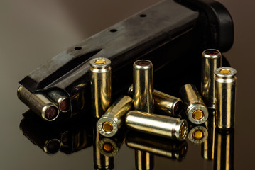 The loaded holder for the gun and cartridges against a dark background