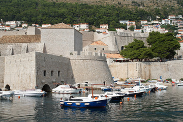Fototapeta na wymiar Boats in the harbor in the old town near the castle walls. Dubronik, Croatia