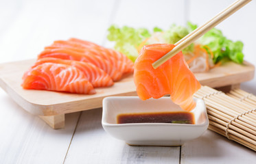 salmon sashimi  with chopsticks. - obrazy, fototapety, plakaty