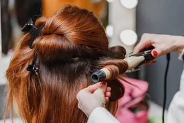 Crédence de cuisine en verre imprimé Salon de coiffure Hairdresser working at the beauty studio salon, making hair styl