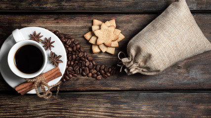 Coffee composition with black coffee, cinnamon and cookies on the old wooden table  
