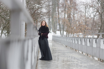 beautiful girl standing on the pedestrian bridge in winter