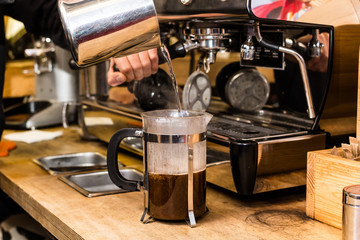 Barista making non traditional coffee in french press