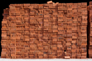 Total block of irregularly stacked building red bricks