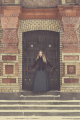 Naklejka premium a beautiful girl standing at the lattice wrought
