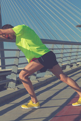 Urban jogger stretching on the bridge.