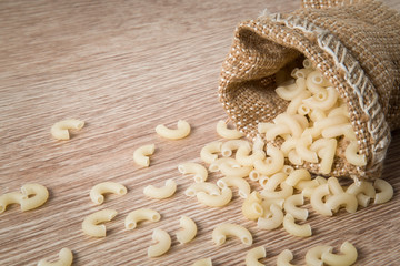 Macaroni pasta in the burlap bag. Healthy eating and lifestyle.