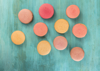 Various macarons on vibrant blue texture with copyspace