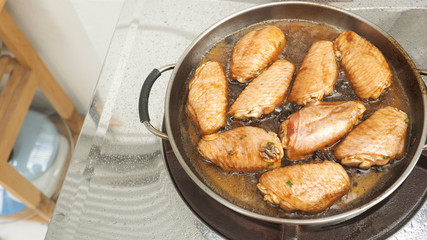 Marinated chicken wings cooking fried pan