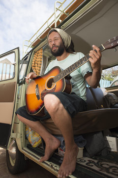 Man with guitar in vehicle