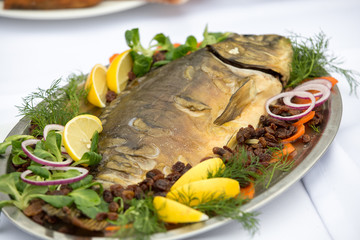 carp  with lemon, dill and raisins on plate