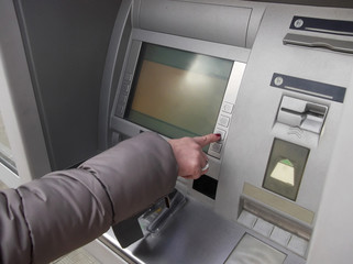 Close up of hand entering pin at an ATM. Woman using banking machine. 