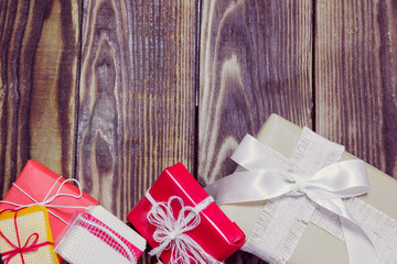 gifts in a different packages on a wooden background