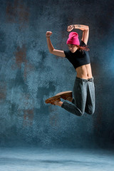 Young girl break dancing on wall background.