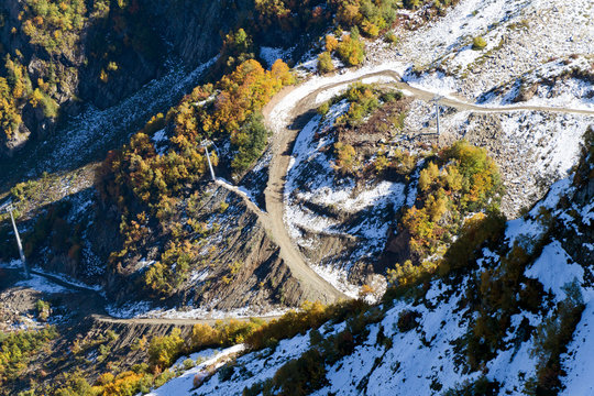 The tops of the mountains covered with snow. The slopes are thic