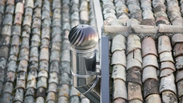 Comignolo caminetto sopra le tegole di un tetto di una casa