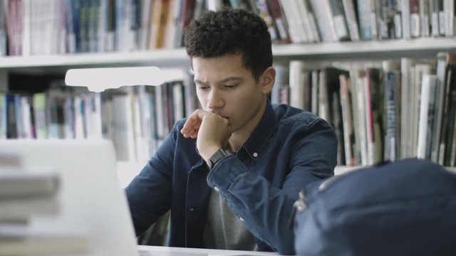 Student studying in library with laptop