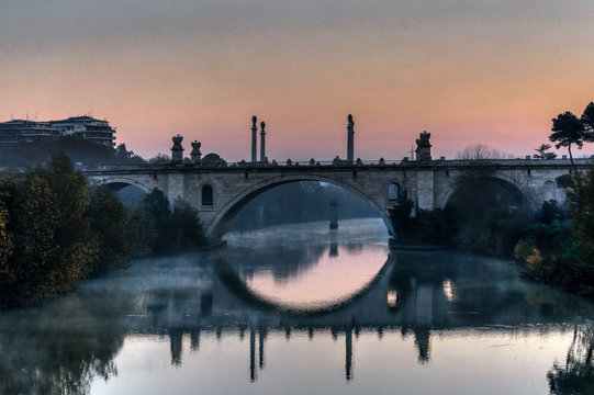 Ponte Flaminio reflecting on the Tiber River at sunrise