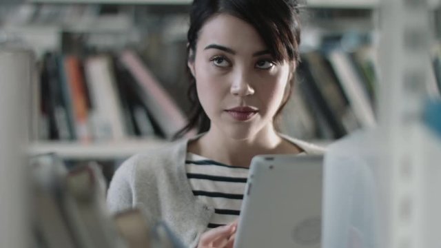 Student using digital tablet in library