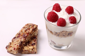 Yogurt with different seeds and berries, raspberries on white background.Cereal bars. Ready to eat.