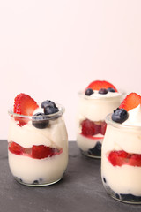 Creamy dessert with berries, raspberries, blueberries strawberries on the stone slate board