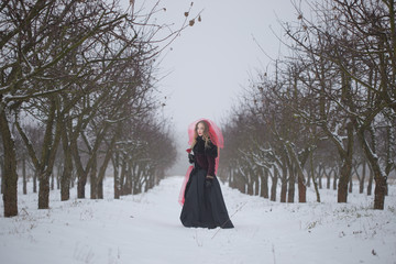 girl in a red veil on the snow in the winter