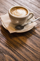 Coffee Cup and Saucer on a Wooden Table. Dark Background. Good Morning or Coffee Break Concept.