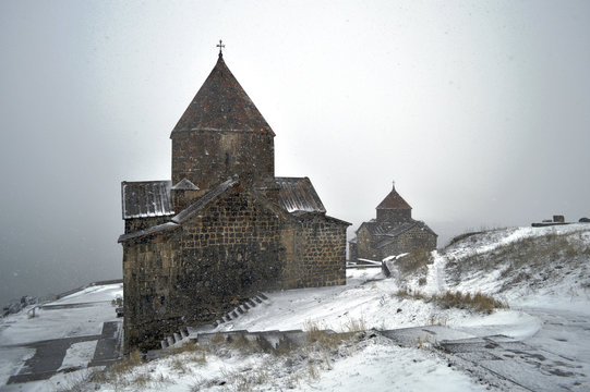 Armenian monastery Sevanavank covered with snow in the fog.