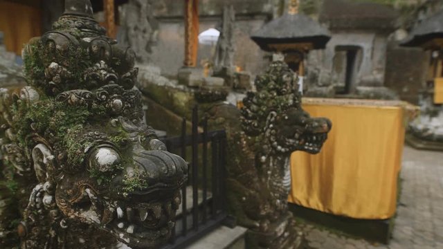 Close up of bronze dragon statues in temple on Bali island. Two oriental ancient sculptures of mythical beings are fixed to protect monkhood from evil spirits.