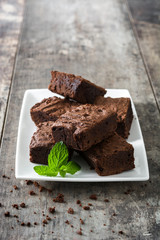 Chocolate brownie portions on wooden background
