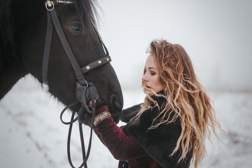Fototapeta na wymiar a girl with a horse in a field in winter