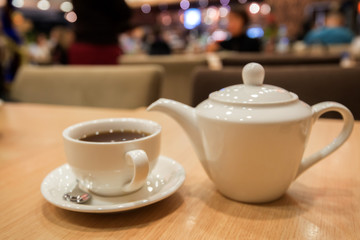 Teapot and cup of tea in cafe