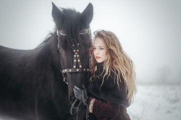 Fototapeta na wymiar a girl with a horse in a field in winter